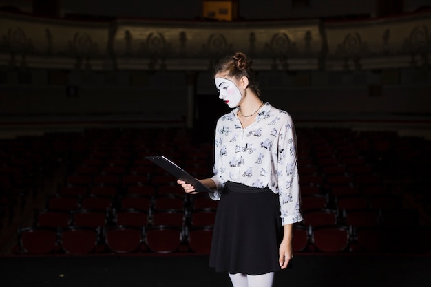 Mime féminin lisant manuscrit sur scène