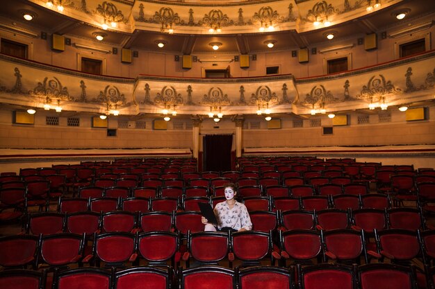 Mime féminin avec manuscrit assis au centre de l&#39;auditorium