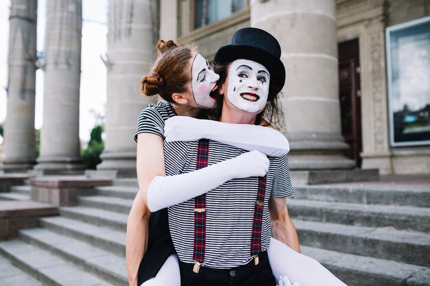 Mime féminin mordant l&#39;oreille mâle mime