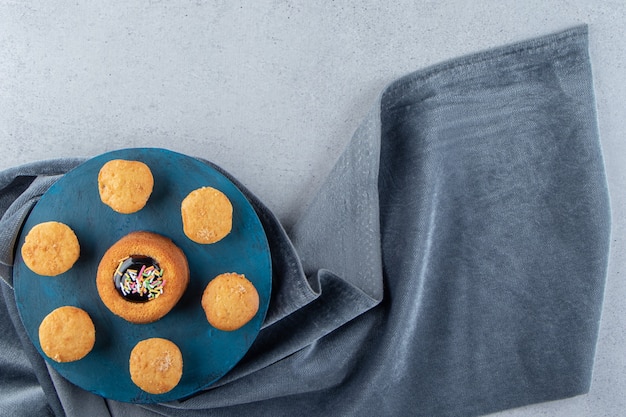 Mini gâteau sucré avec de la gelée et des biscuits sur un tableau bleu