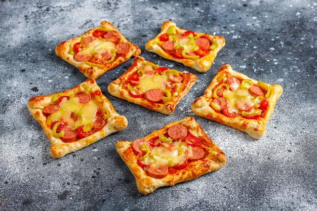 Mini pizzas de pâte feuilletée avec saucisses.