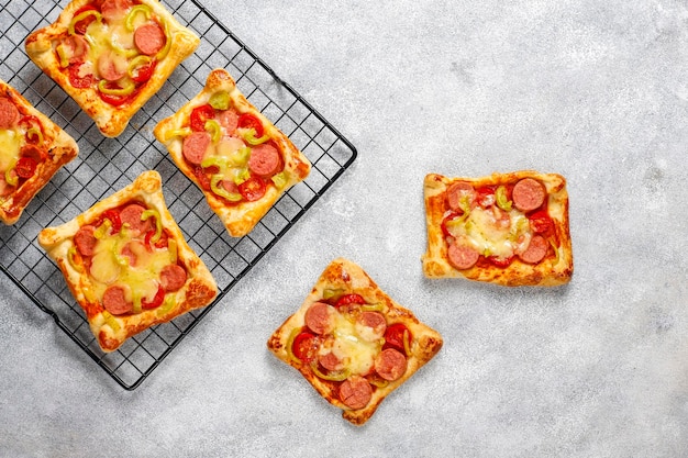 Photo gratuite mini pizzas de pâte feuilletée avec saucisses.