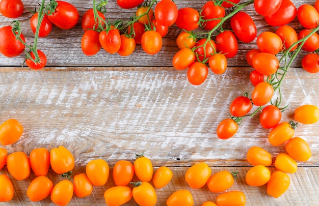 Mini tomates colorées sur table en bois, pose à plat.