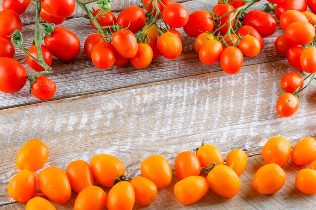 Mini tomates colorées sur une table en bois. vue grand angle.