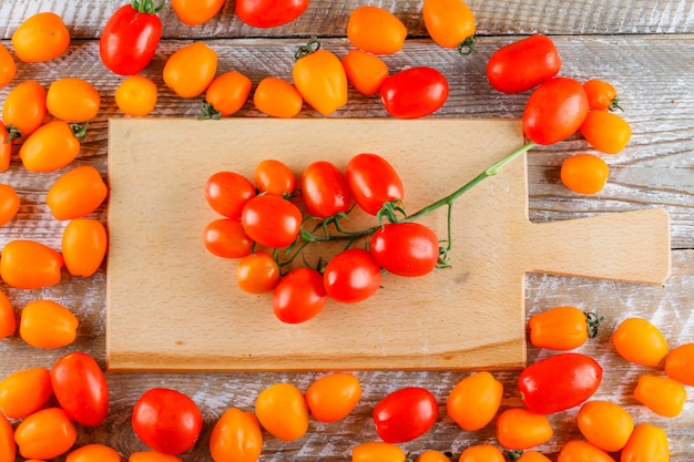 Mini tomates sur planche de bois et à découper. pose à plat.