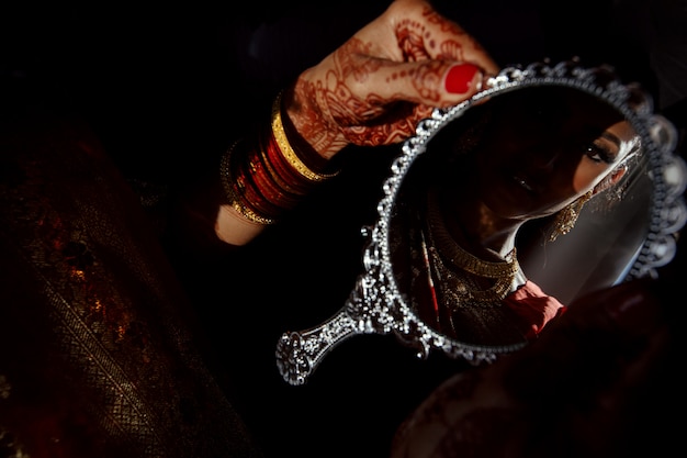 Miroir en argent dans les mains d&#39;une mariée hindoue avec des tatouages au henné
