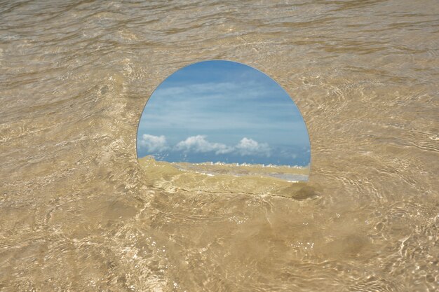 Miroir rond en verre à la plage reflétant le paysage