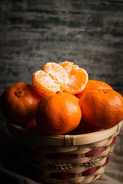 Mise au point peu profonde d'un panier avec des mandarines sur fond sombre
