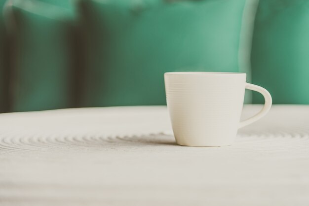 Mise au point sélective sur le café noir dans une tasse blanche - effet de filtre vintage