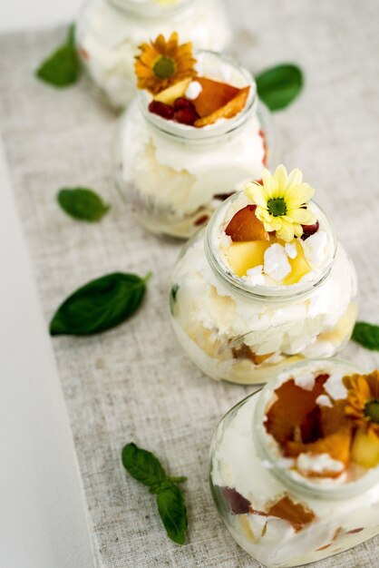 Mise au point sélective de délicieuses et douces glaces à la vanille dans des bocaux en verre décorés de fleurs jaunes