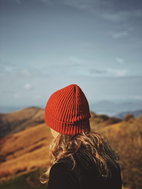 Mise au point sélective sur une femme au chapeau rouge avec un flou