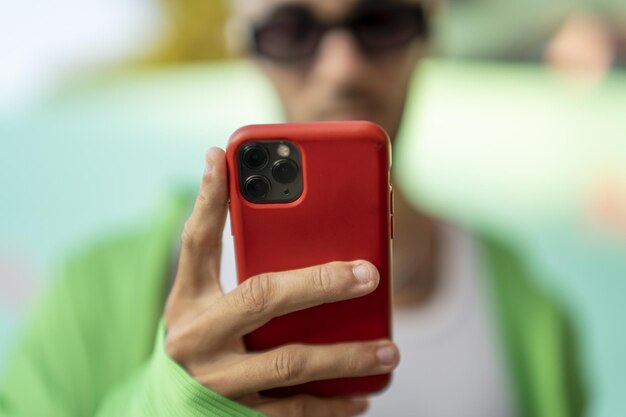 Mise au point sélective d'une personne regardant le smartphone dans un étui rouge