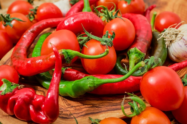 Photo gratuite mise au point sélective sur le poivron chaud et les tomates sur une planche de bois gros plan sur les produits frais d'un marché fermier ingrédients alimentaires du régime méditerranéen et de l'alimentation saine