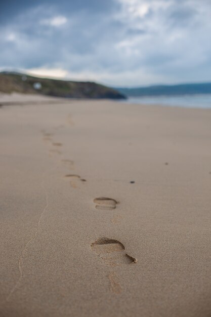Mise au point sélective verticale d'une plage de sable sous le ciel clair à Cornwall, Angleterre