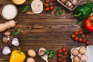 Photo gratuite mise en page créative faite de légumes frais et de grains de riz sur un bureau en bois