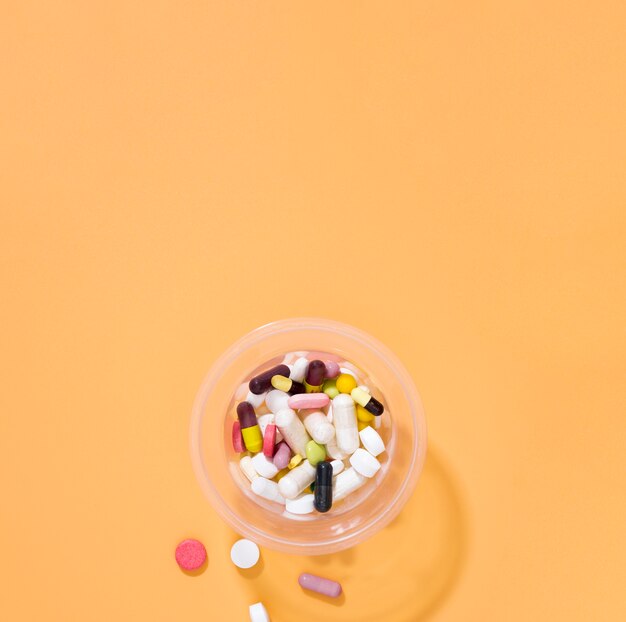 Mise à plat d'assortiment de pilules dans une tasse en plastique avec espace copie