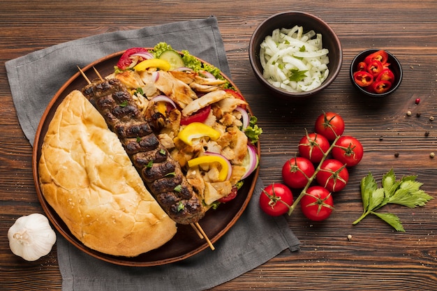 Mise à plat de l'assortiment de savoureux kebab aux tomates et herbes