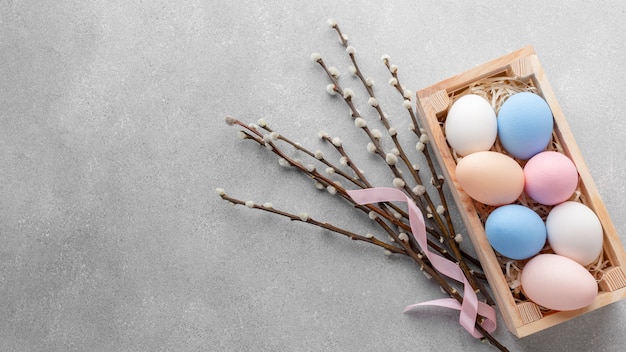 Mise à plat de boîte avec des oeufs de Pâques colorés et espace copie