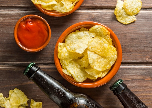 Photo gratuite mise à plat de bouteilles de bière avec des chips