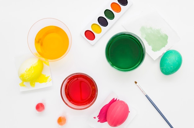 Mise à plat de colorants colorés pour les oeufs de Pâques avec palette et pinceau