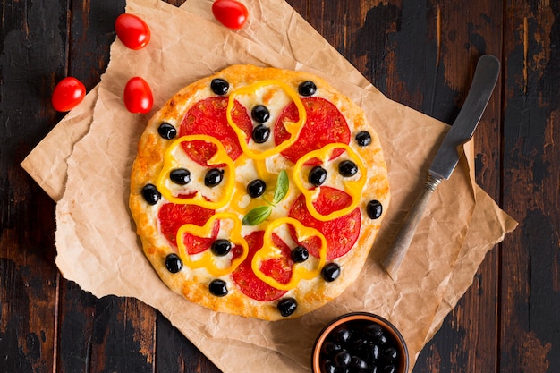 Photo gratuite mise à plat de délicieuses pizzas sur table en bois
