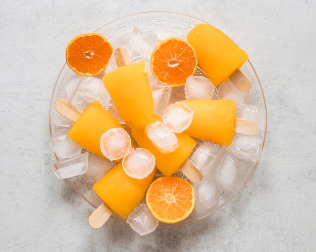 Mise à plat de délicieux sucettes glacées à l'orange avec de la glace