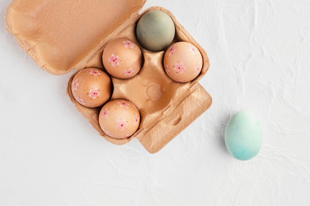 Photo gratuite mise à plat du carton avec des oeufs de pâques