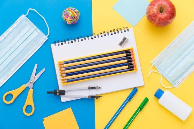 Mise à plat du matériel de retour à l'école avec des crayons et des ciseaux