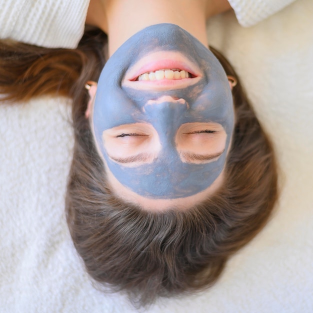 Mise à plat de femme à la maison avec masque facial