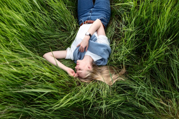 Mise à plat de femme posant dans l'herbe