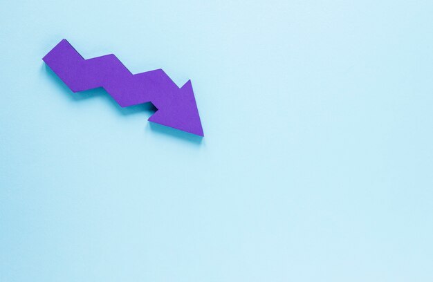 Mise à plat flèche violette sur fond bleu avec copie-espace
