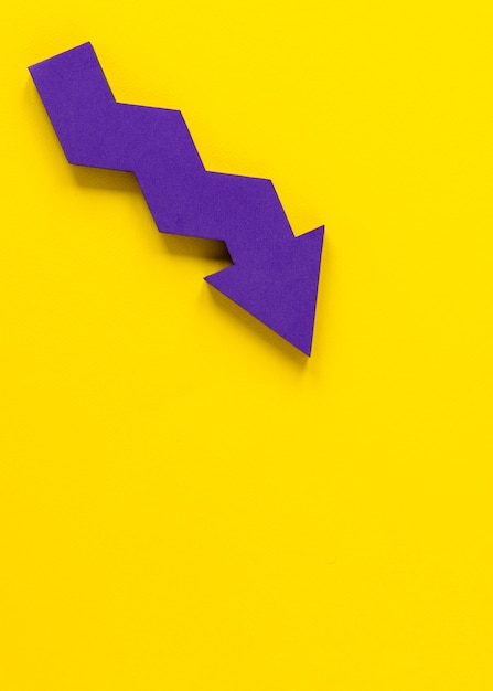 Mise à plat flèche violette sur fond jaune avec copie-espace
