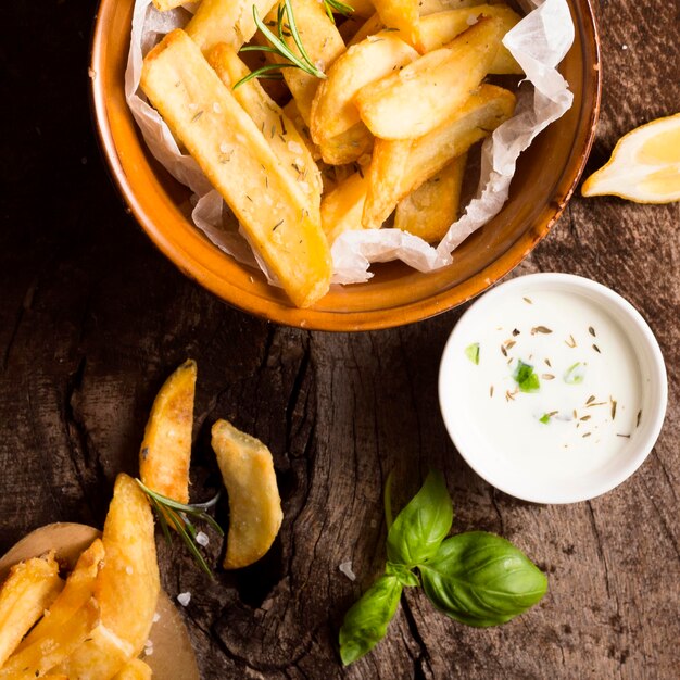 Mise à plat de frites dans un bol avec sauce spéciale et herbes