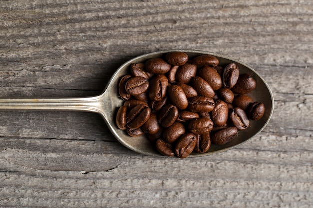 Photo gratuite mise à plat des grains de café en cuillère