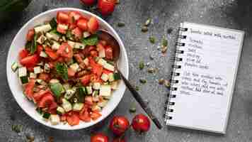 Photo gratuite mise à plat des ingrédients alimentaires avec salade et cahier