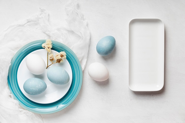 Mise à Plat D'oeufs De Pâques Sur Des Assiettes Avec Des Fleurs