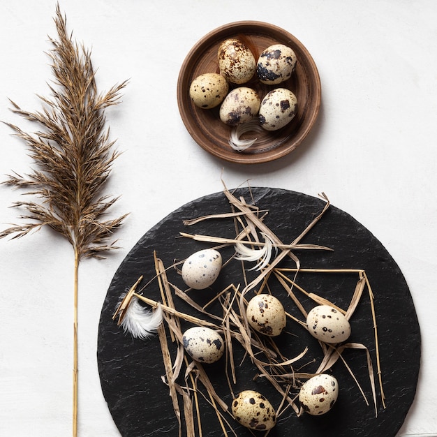 Photo gratuite mise à plat d'oeufs de pâques sur plaque en bois et ardoise