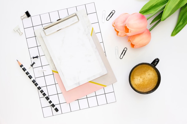 Mise à plat de papeterie de bureau avec café et tulipes