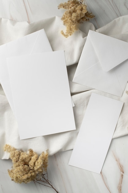 Mise à plat de papier de mariage et enveloppe avec plantes séchées