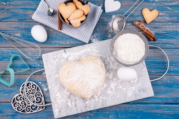 Photo gratuite mise à plat de pâte en forme de coeur avec des cookies de la saint-valentin