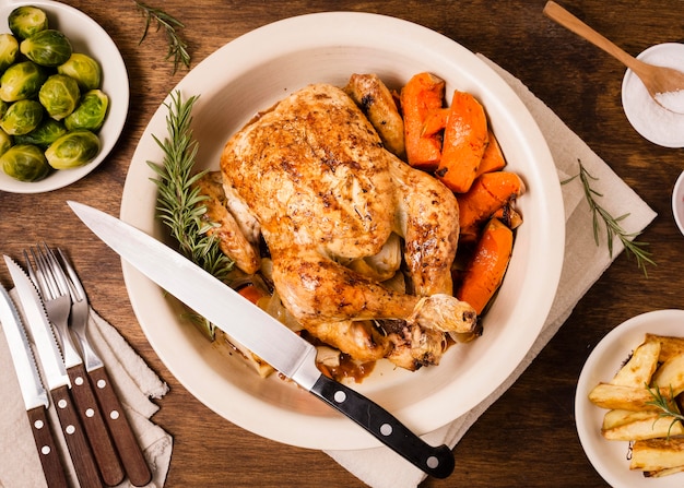 Mise à plat de la plaque avec du poulet rôti de Thanksgiving et d'autres plats