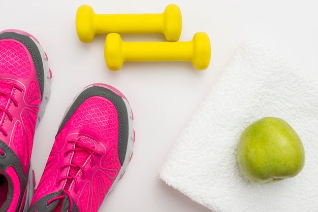 Photo gratuite mise à plat de poids avec des baskets et pomme