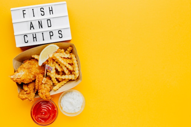 Mise à plat de poisson et frites avec sauce et boîte à lumière