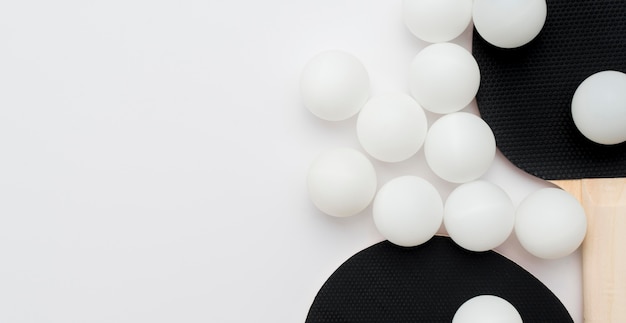 Photo gratuite mise à plat de la raquette de ping-pong avec espace copie et beaucoup de balles