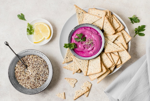 Photo gratuite mise à plat de sauce rose avec des craquelins et du citron