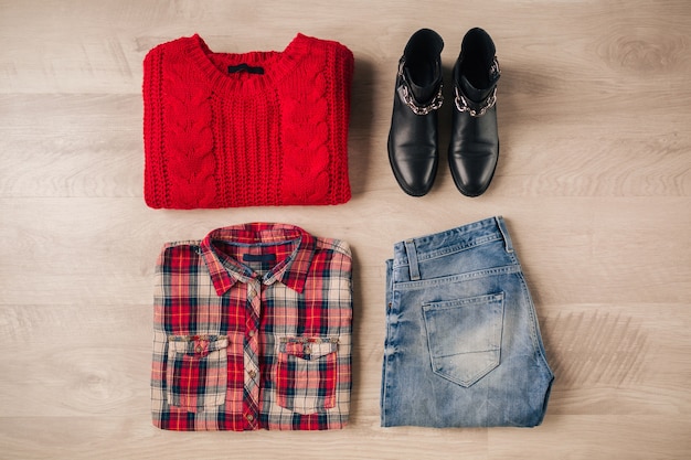 Mise à plat de style femme et accessoires, pull en tricot rouge, chemise à carreaux, jeans en denim, bottes en cuir noir, tendance de la mode automne, vue d'en haut, vêtements