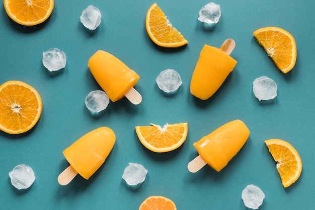 Photo gratuite mise à plat de sucettes glacées délicieuses avec de la glace et de l'orange