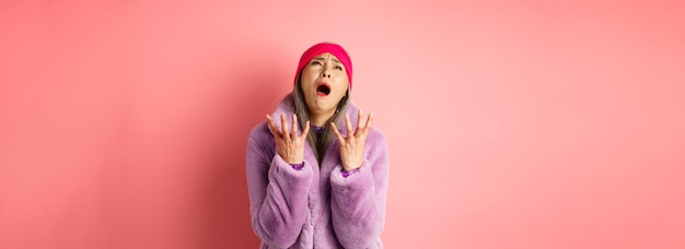 Photo gratuite misérable femme senior asiatique en manteau de fausse fourrure violet élégant implorant dieu et demandant pourquoi secouer han