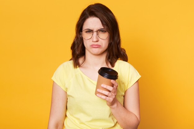 Misérable jeune modèle bouleversé pose isolé sur jaune