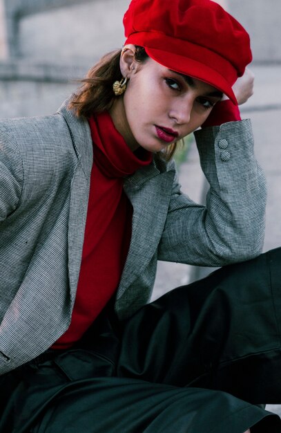 À La Mode Jeune Femme Avec Bonnet Rouge, Regardant La Caméra